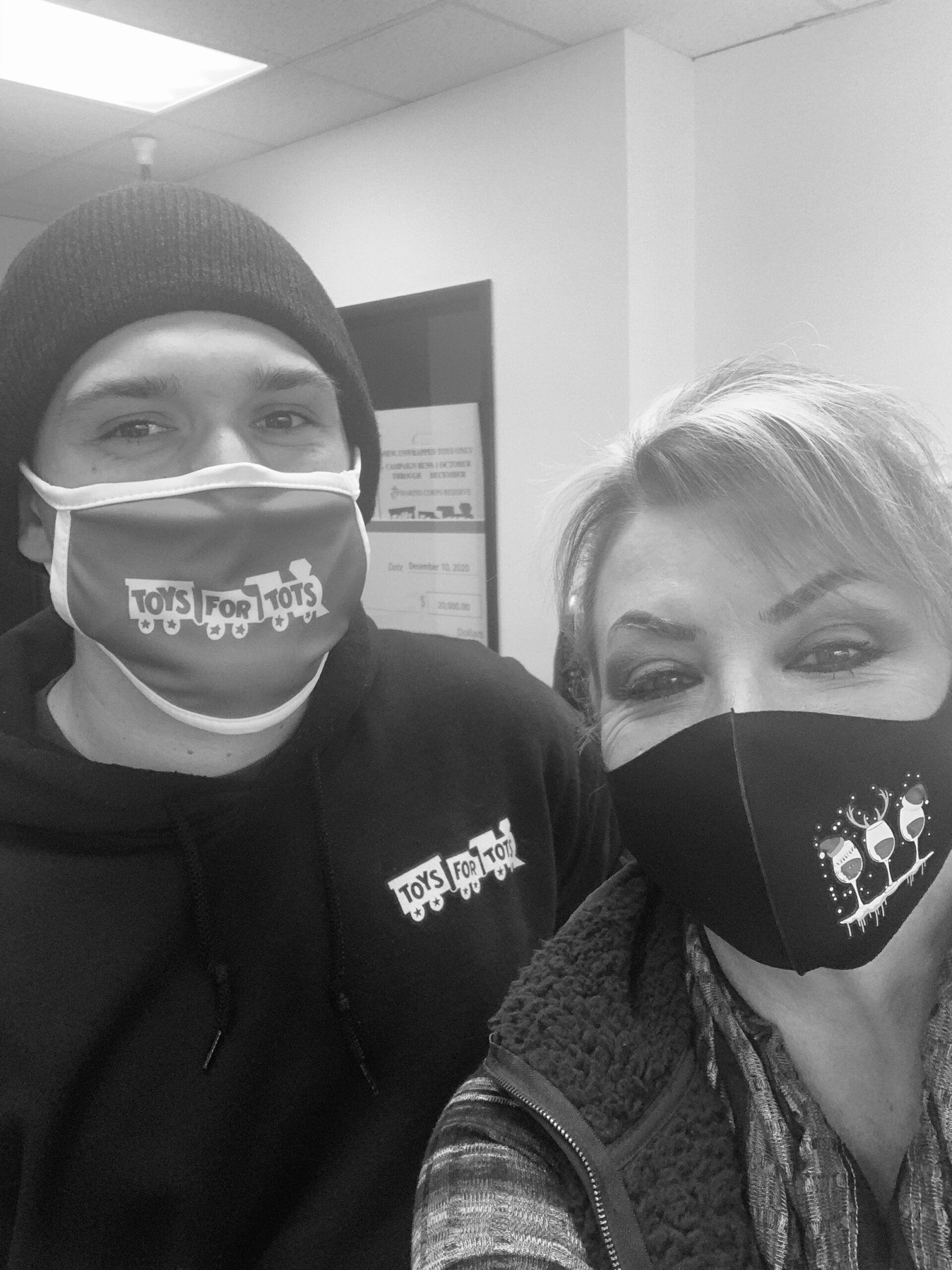 A man and a woman wearing face masks in a black and white photo.