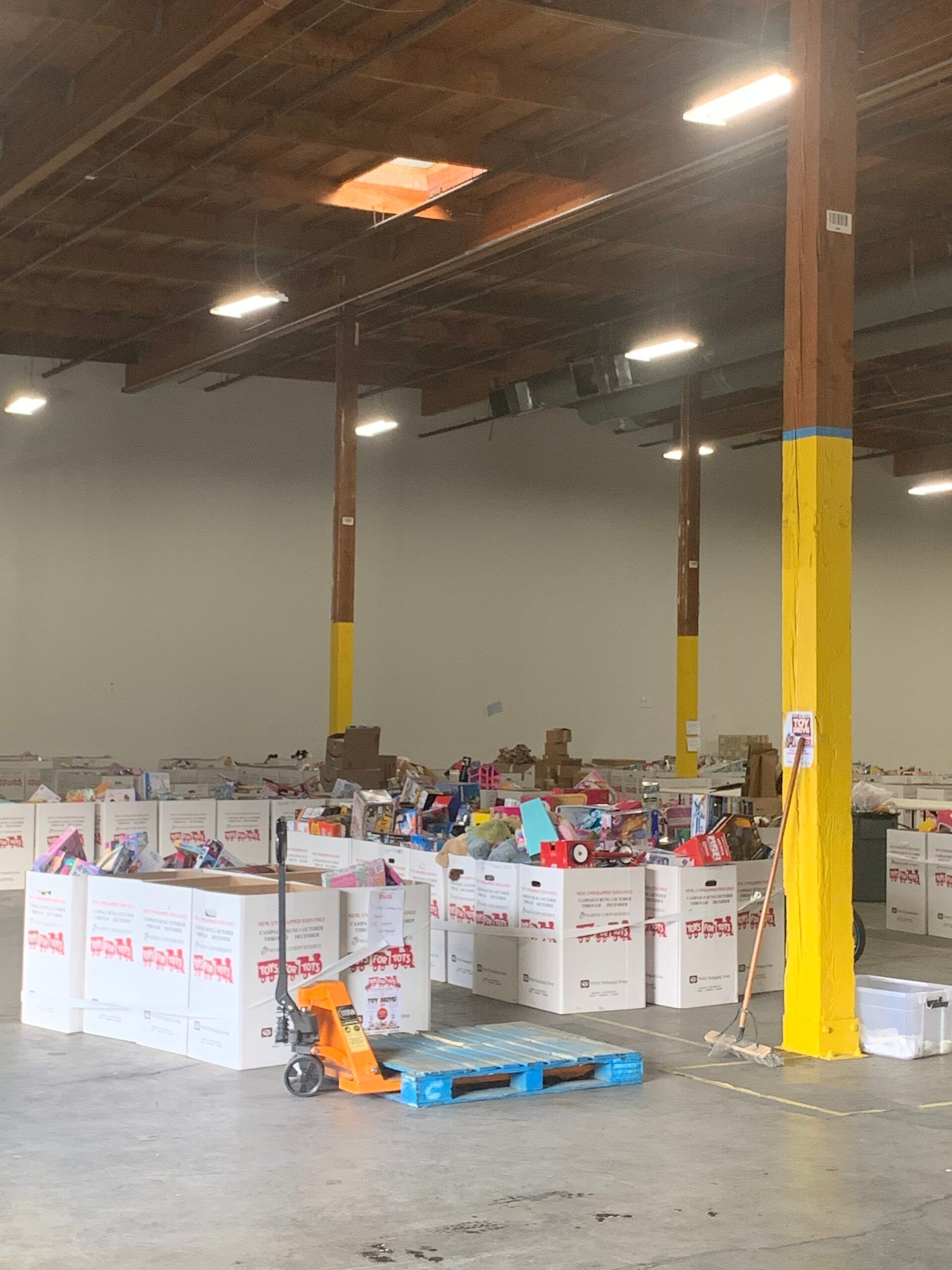 A large warehouse filled with lots of boxes and a hand truck.