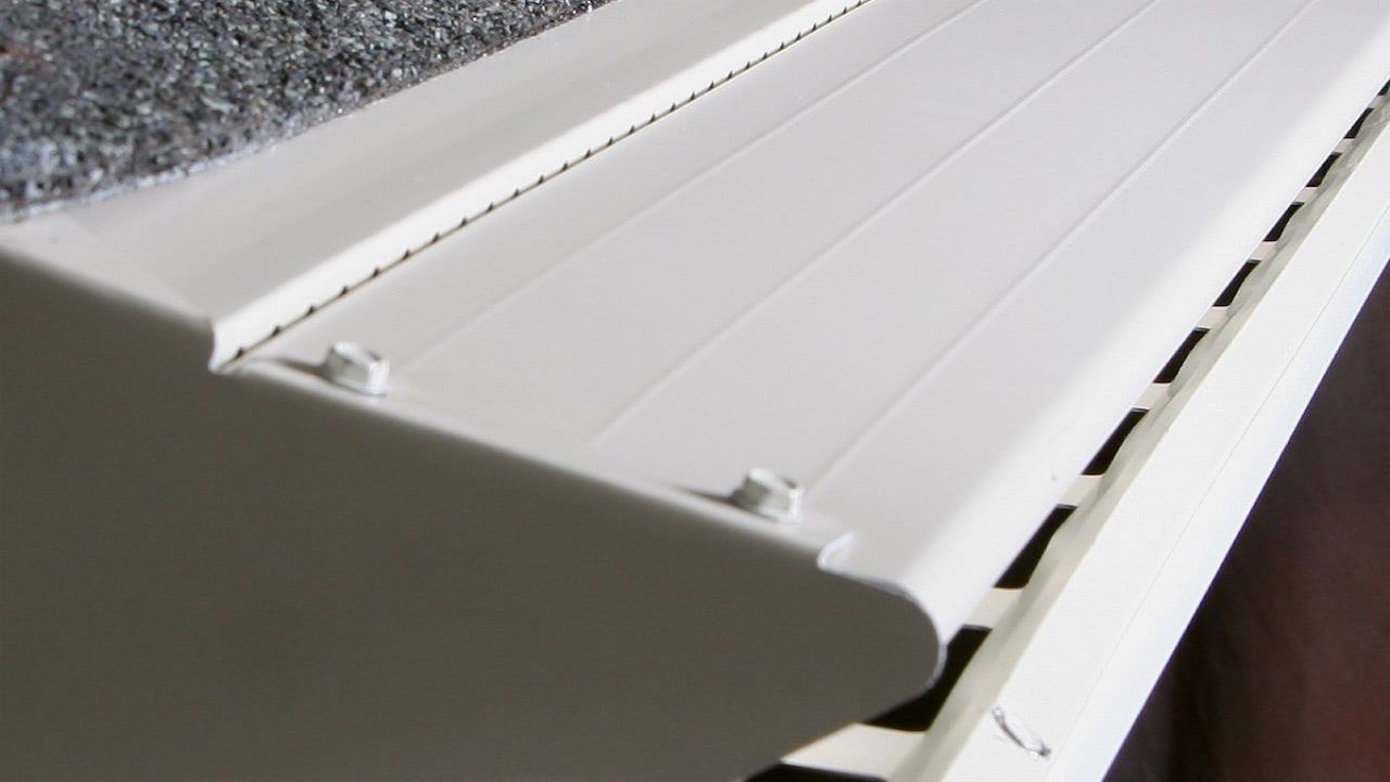 A close up of a white gutter on a roof.