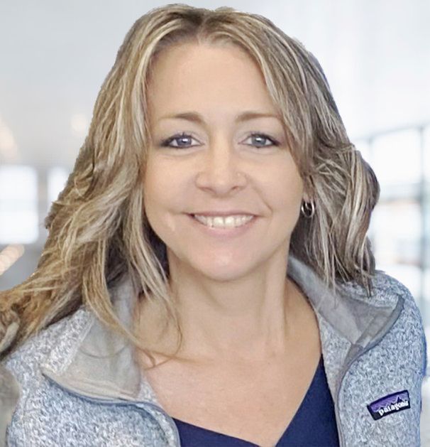 A woman wearing a patagonia jacket is smiling for the camera.