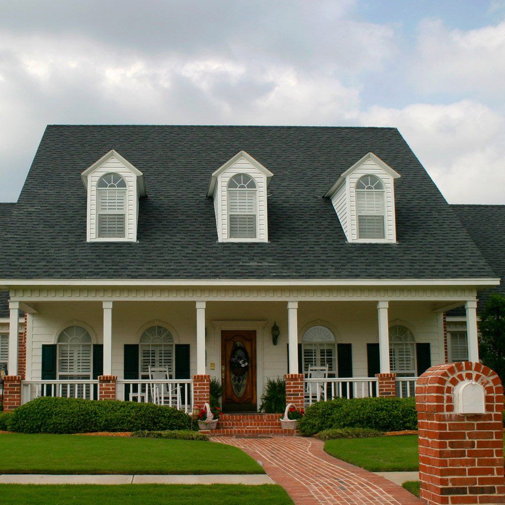 A white house with a black roof and a porch