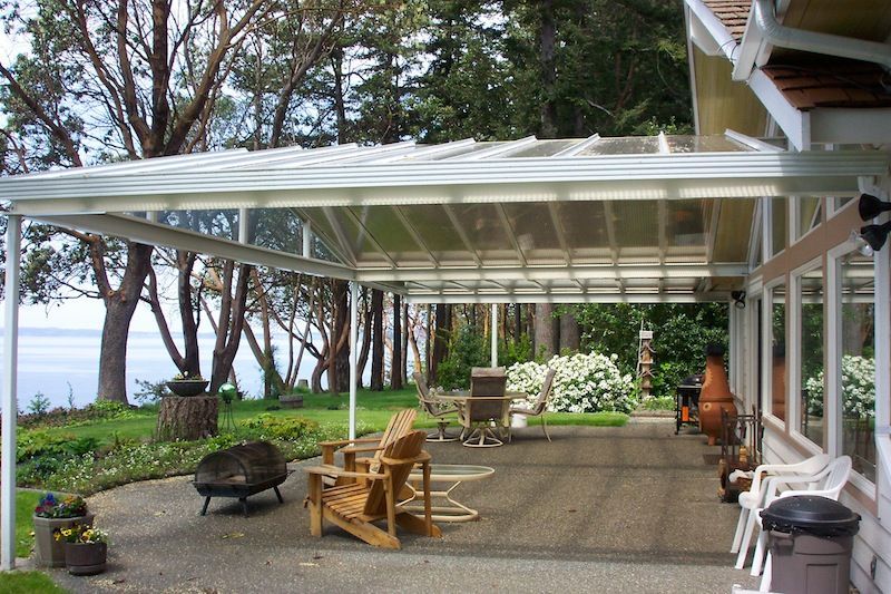A covered patio with chairs and a fire pit