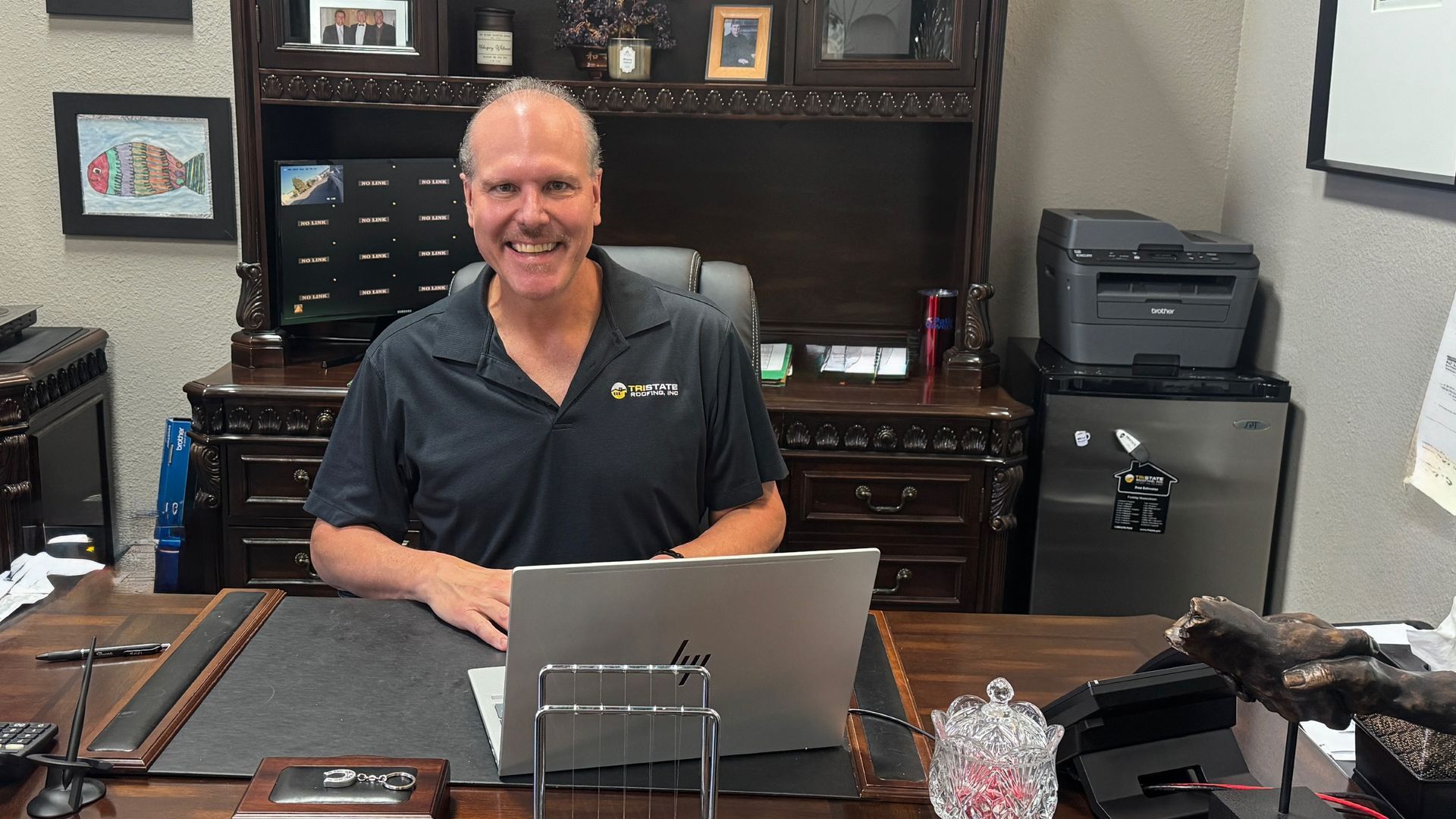 A man in a suit is sitting in a chair in front of a desk.