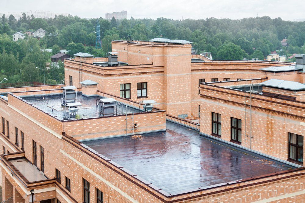 An aerial view of a large brick building with a flat roof.