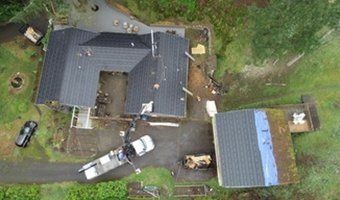 An aerial view of a house under construction with a truck parked in front of it.