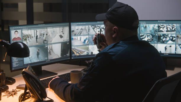 Security officer controls CCTV cameras on computer.
