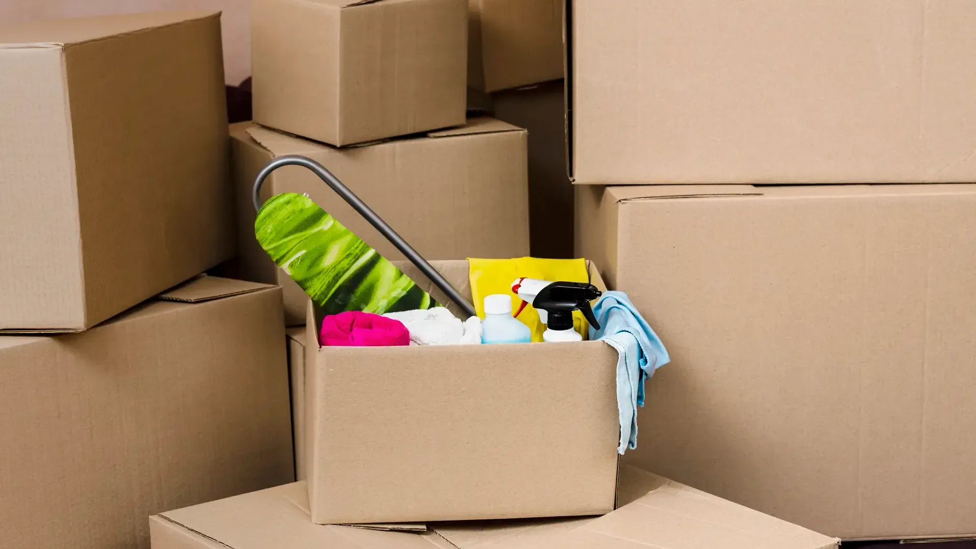 Cleaning supplies box among moving boxes