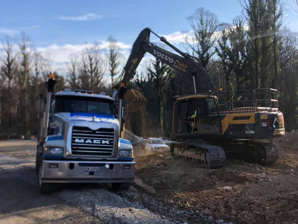 A yellow and black cat excavator is parked in a gravel lot.