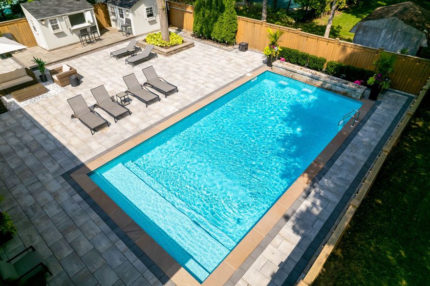 An aerial view of a large swimming pool in a backyard.