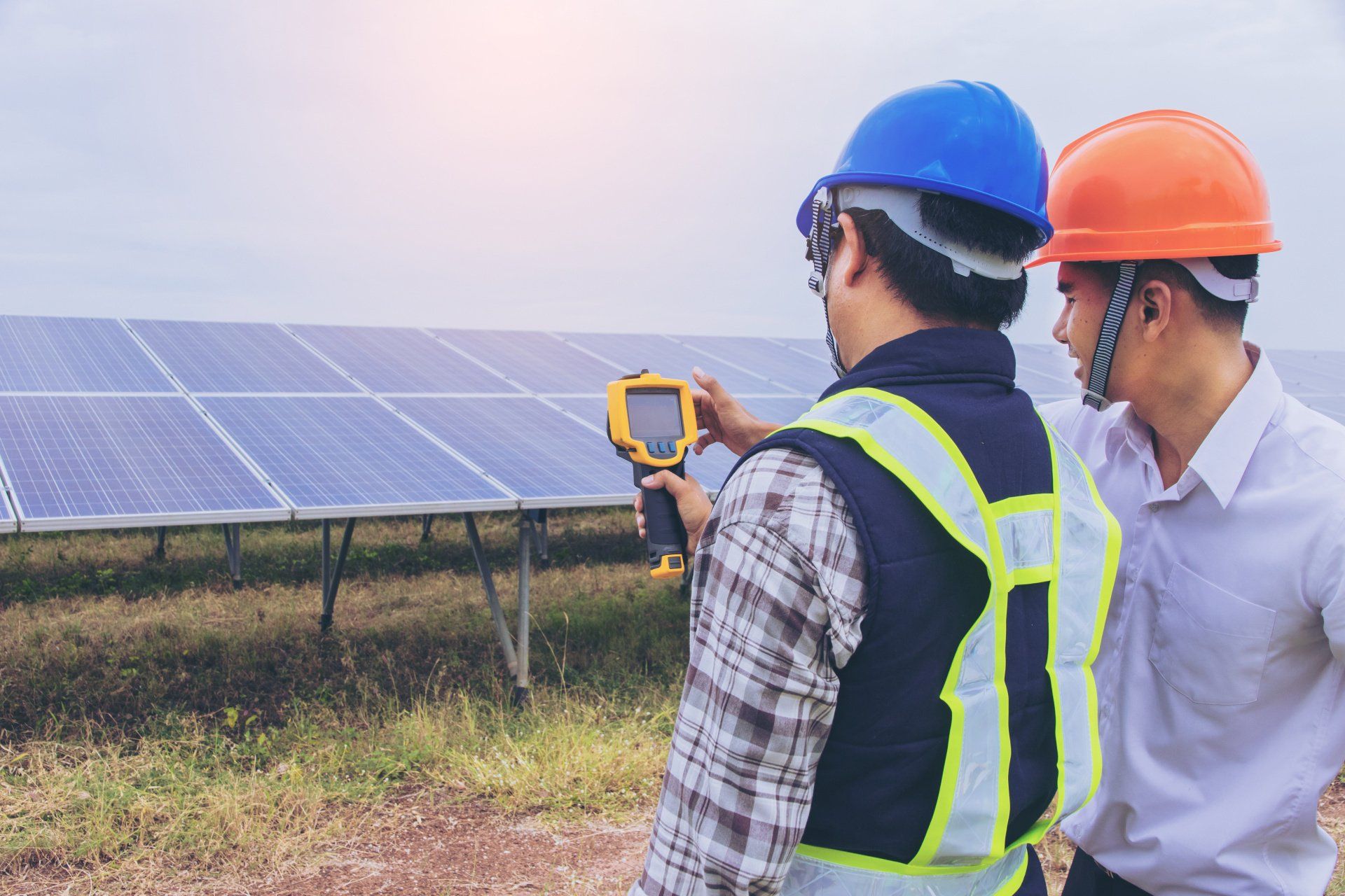 two engineers inspecting a ground mounted solar panel