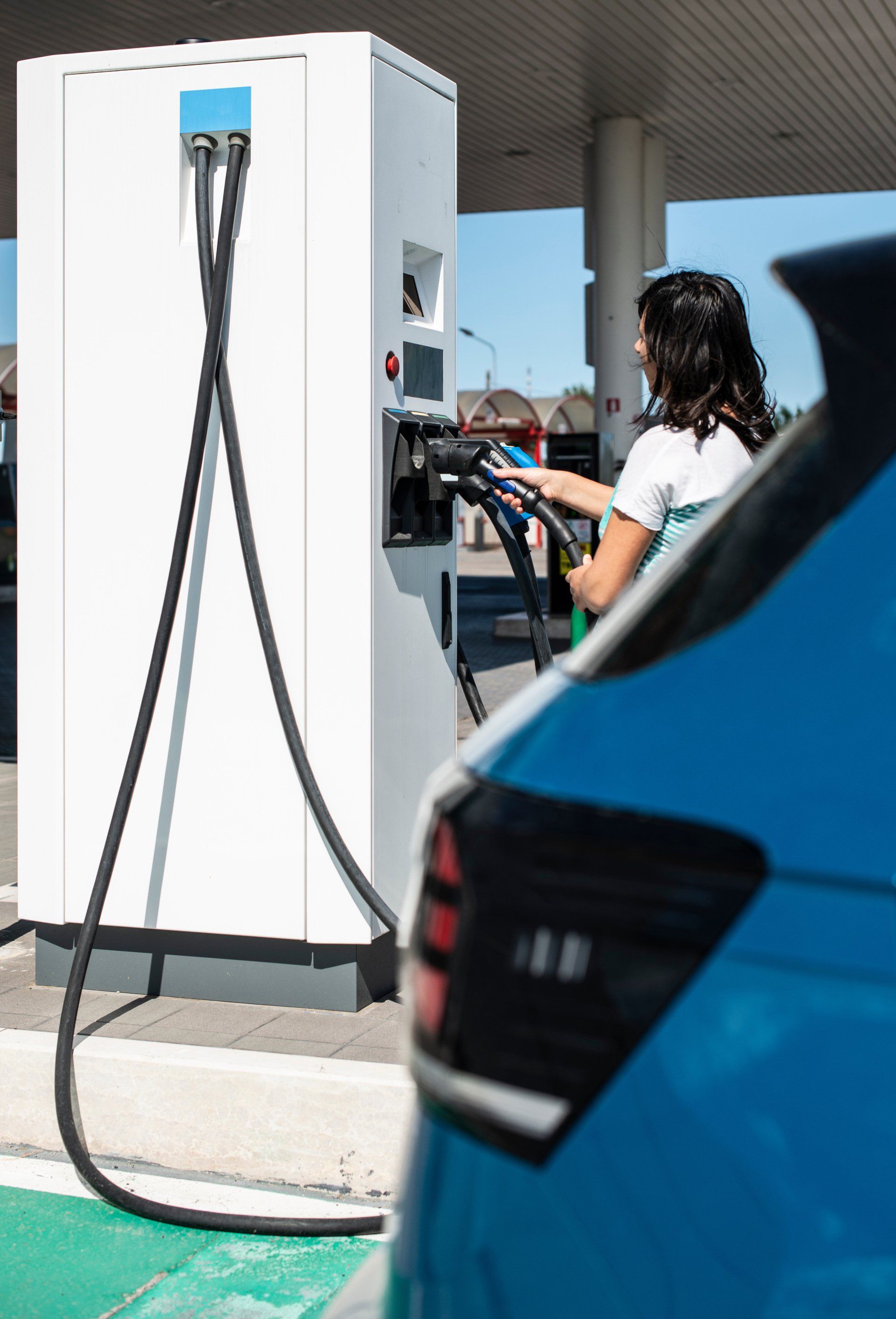 a woman operating an EV charging station