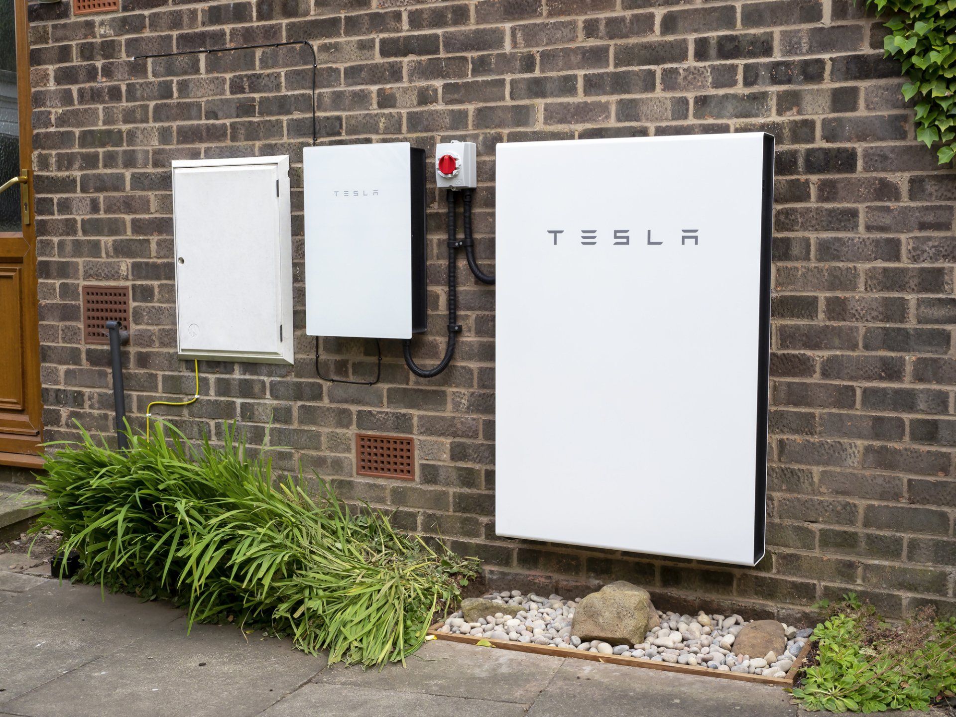 Tesla solar batteries mounted on brick wall