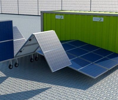 A group of solar panels are sitting in front of a green building.