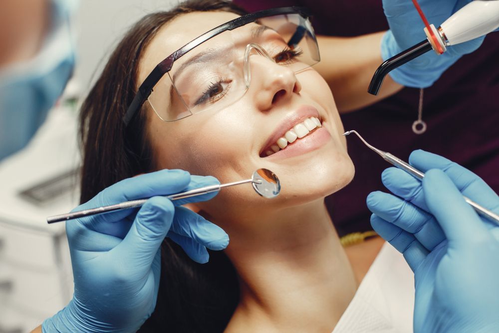 A woman is getting her teeth examined by a dentist.