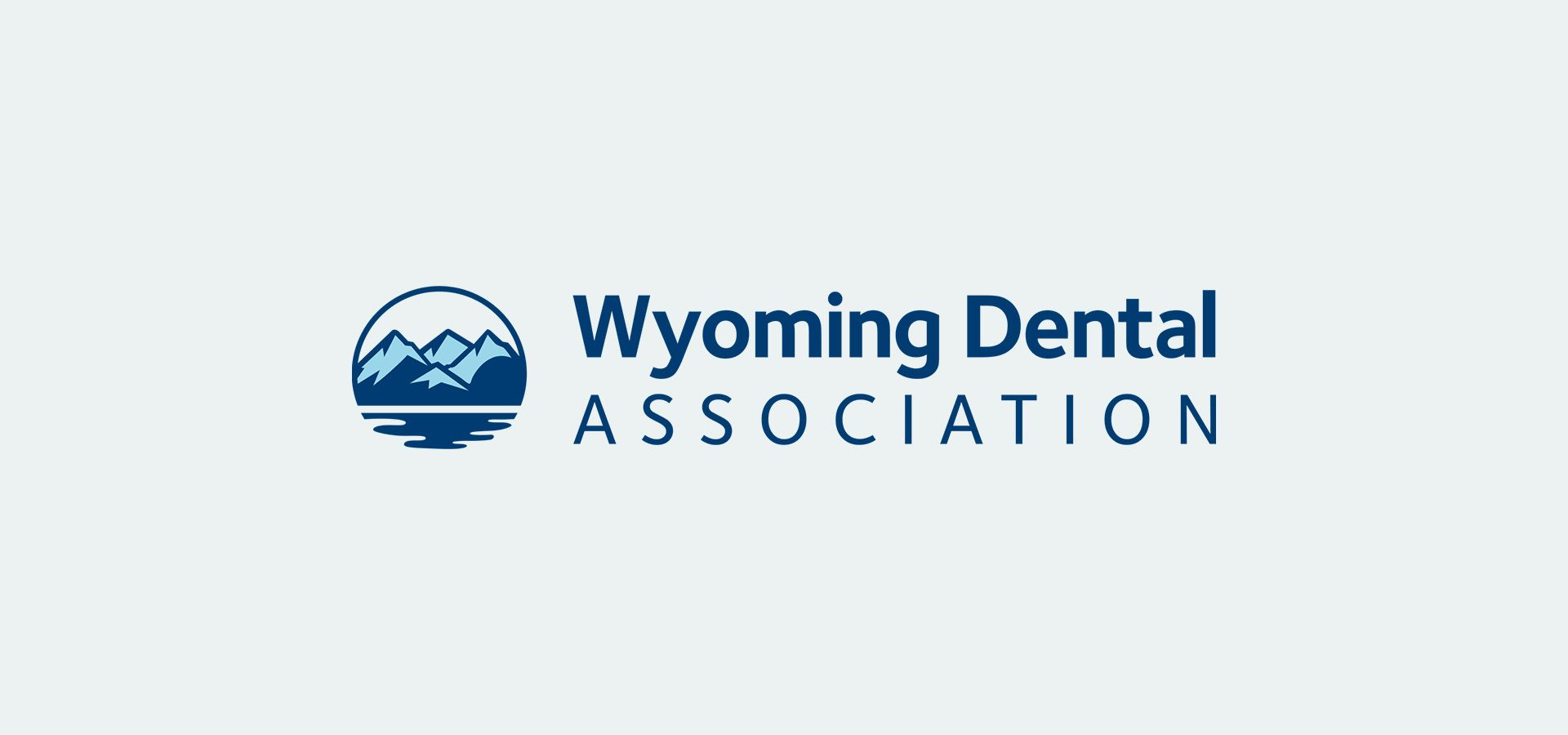 The wyoming dental association logo has a mountain and a lake in it.