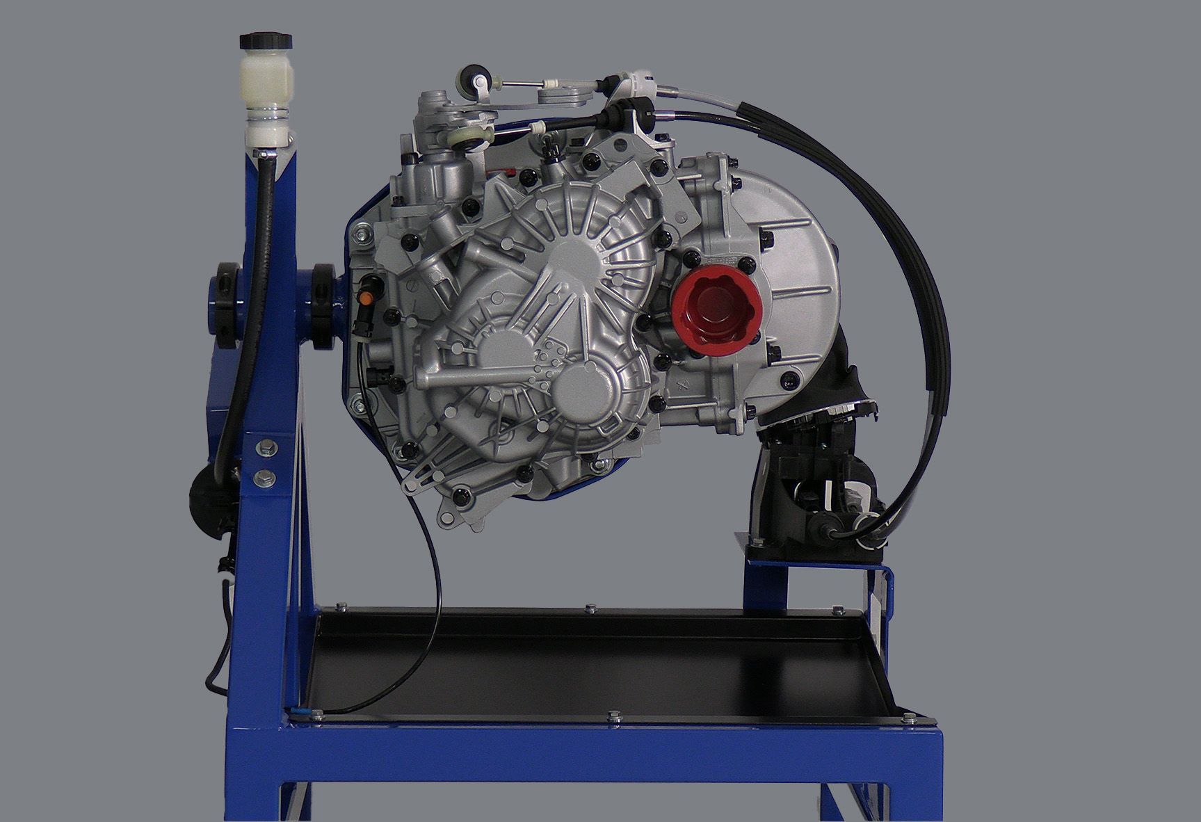 A car engine is sitting on top of a blue stand.