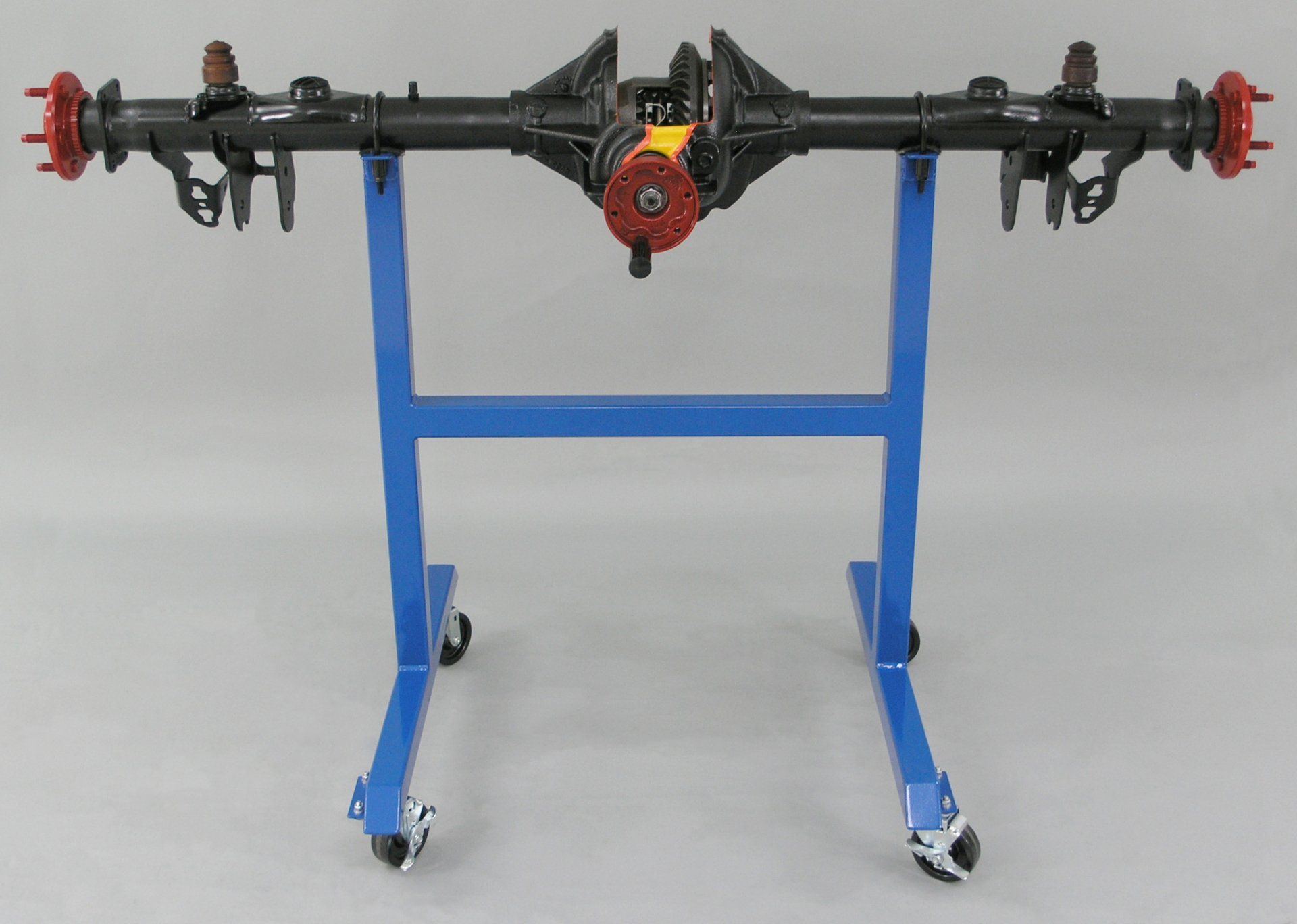 A rear axle on a blue stand with wheels