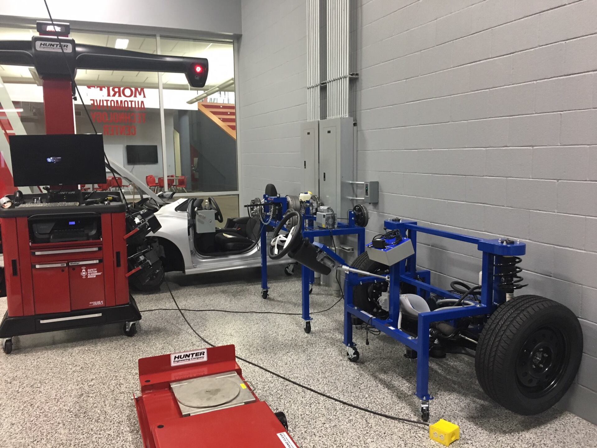 A car is being checked by a machine in a garage.
