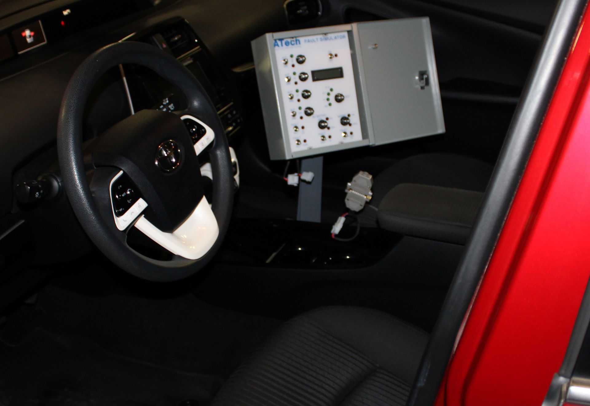 The inside of a red car with a steering wheel and dashboard