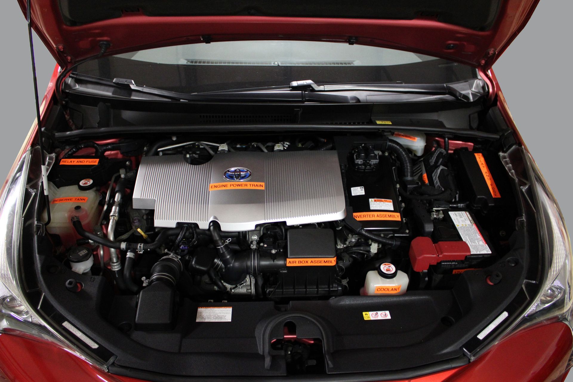 The engine of a red car with the hood open