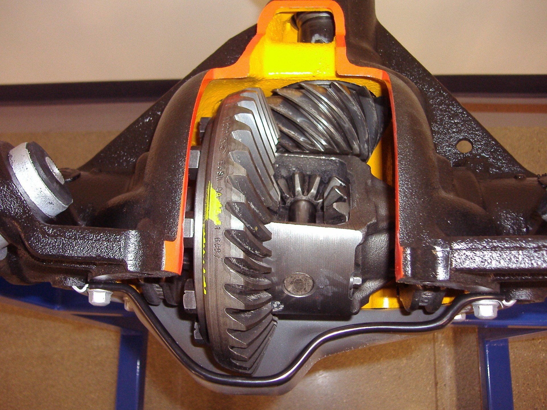 A close up of a rear differential on a blue stand