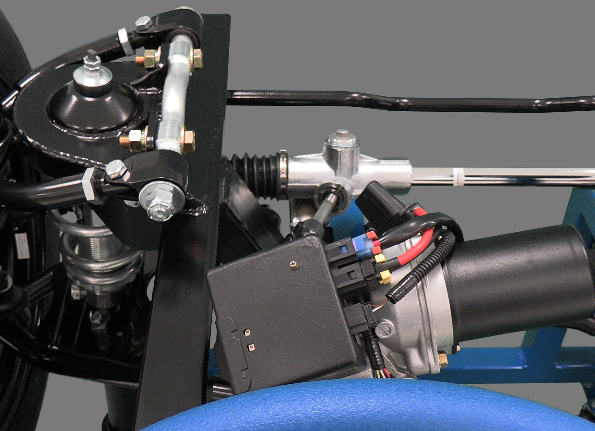 A close up of a car steering system with a blue steering wheel