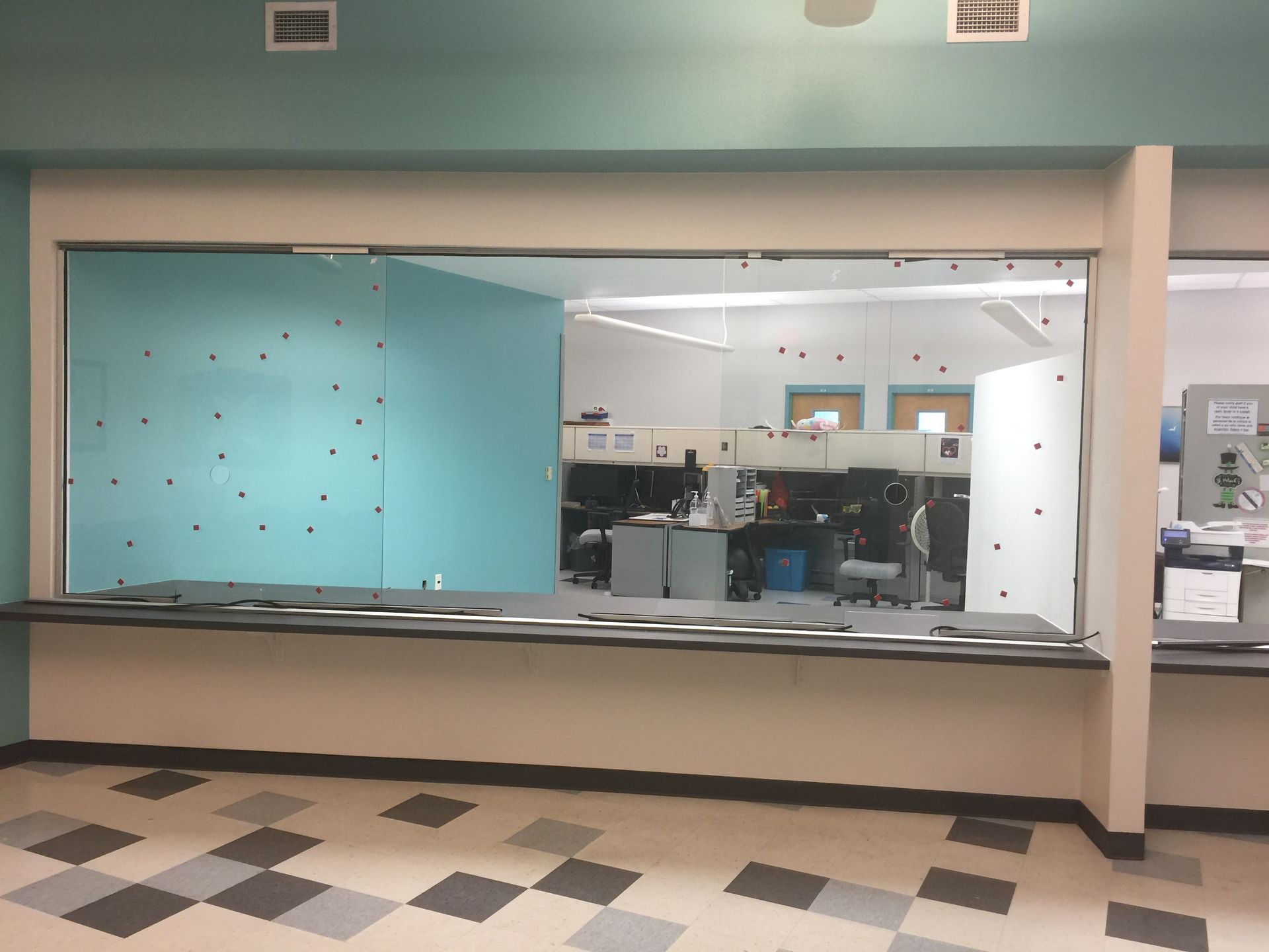 A room with a large window and a checkered floor.