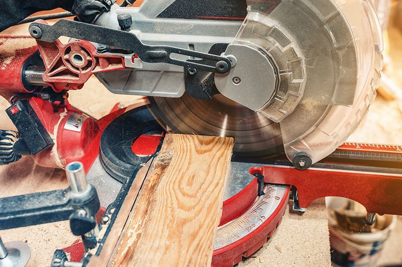 A person is cutting a piece of wood with a circular saw.