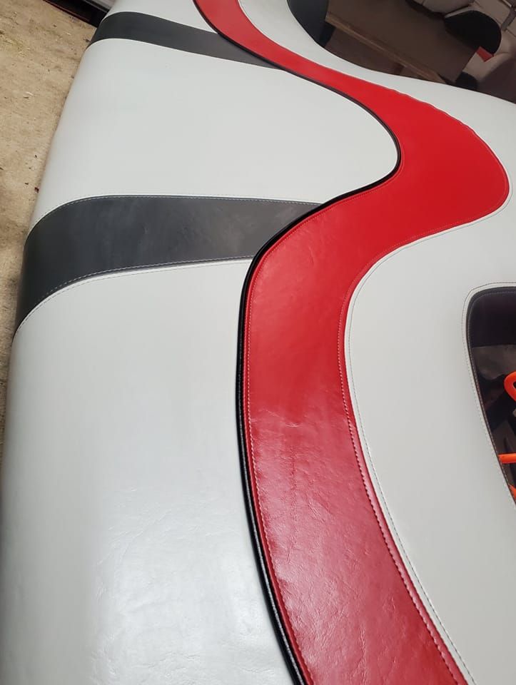 White, red, and gray boat seat with curved design.