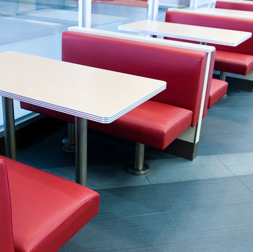 Red diner booths and tables in a brightly lit restaurant.