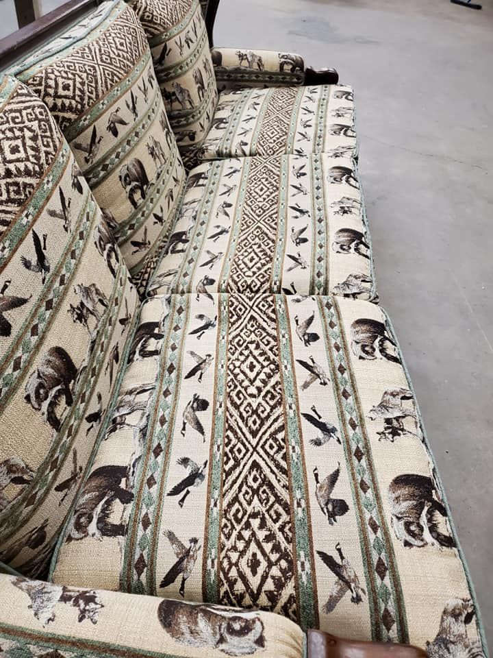 Upholstered sofa with bird and geometric patterns in beige, brown, and green.