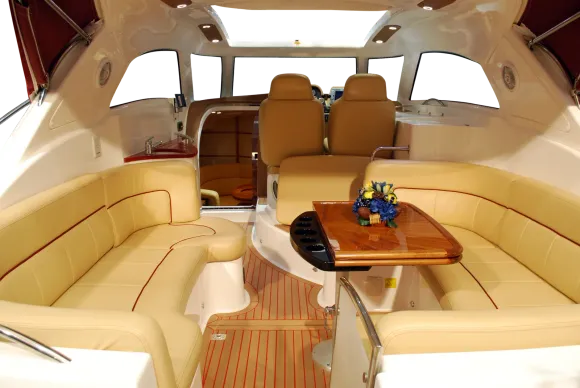 Beige leather car backseats with gray center panels; a window and blurry road are visible.