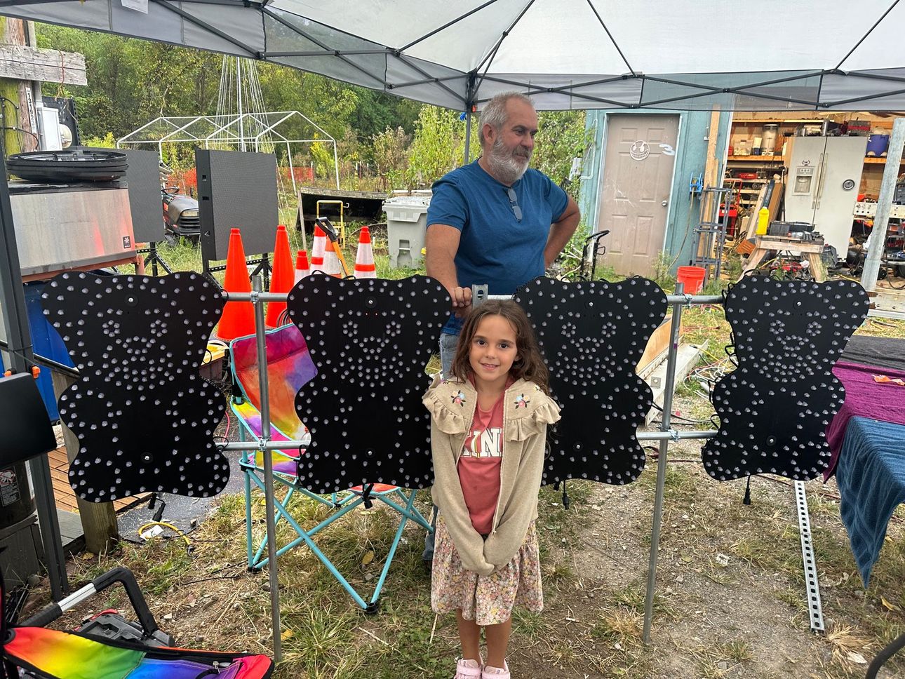 A little girl is standing in front of a display of black teddy bears.