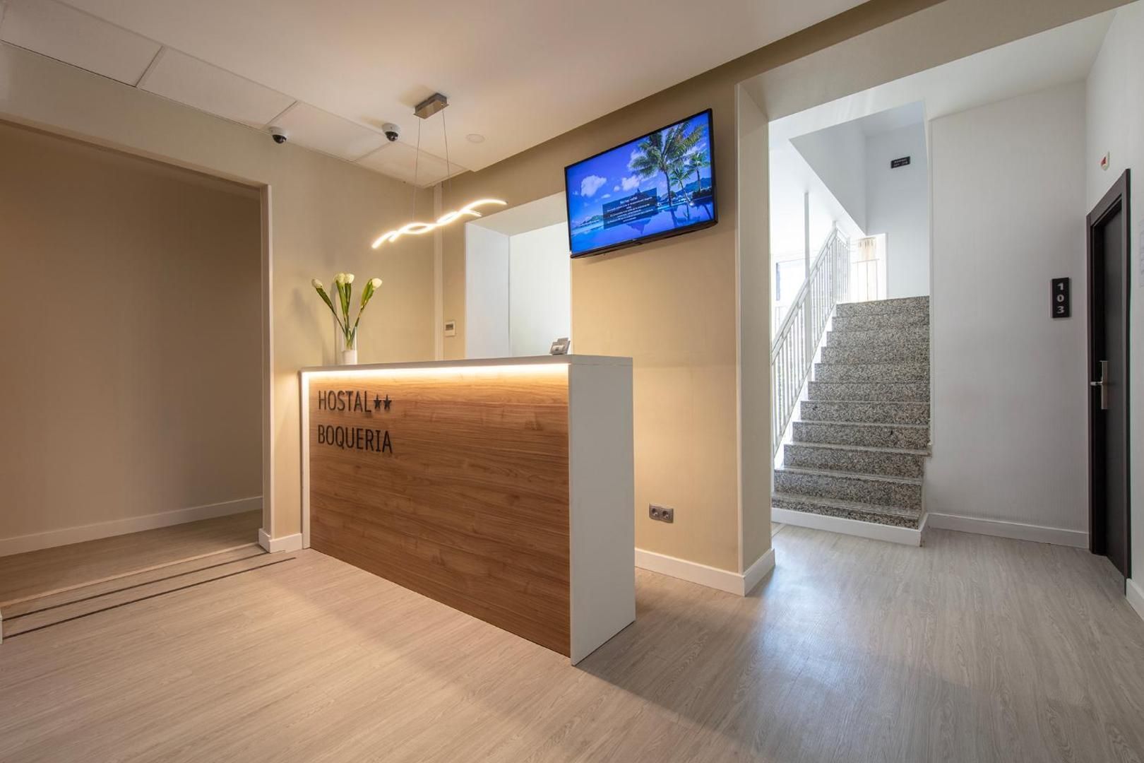 A hotel lobby with a reception desk and stairs.