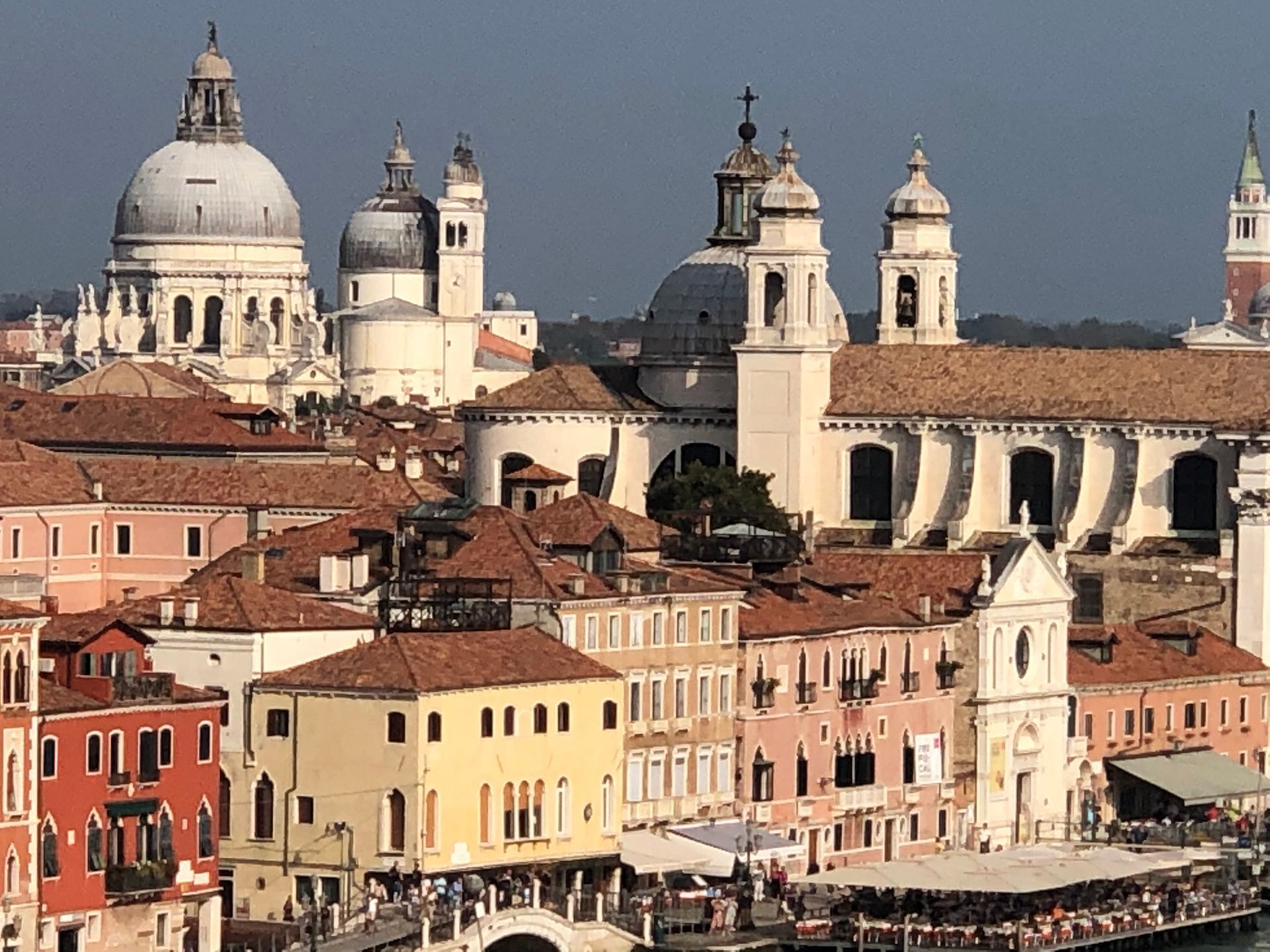 A view of Venetian architecture featuring the Santa Maria della Salute basilica with its large dome overlooking buildings.