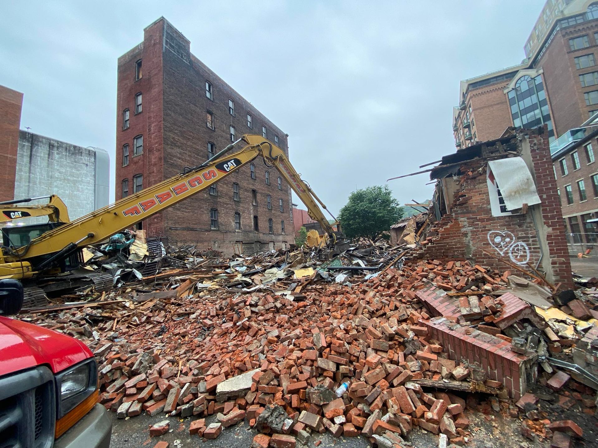 A large pile of bricks in front of a building that is being demolished