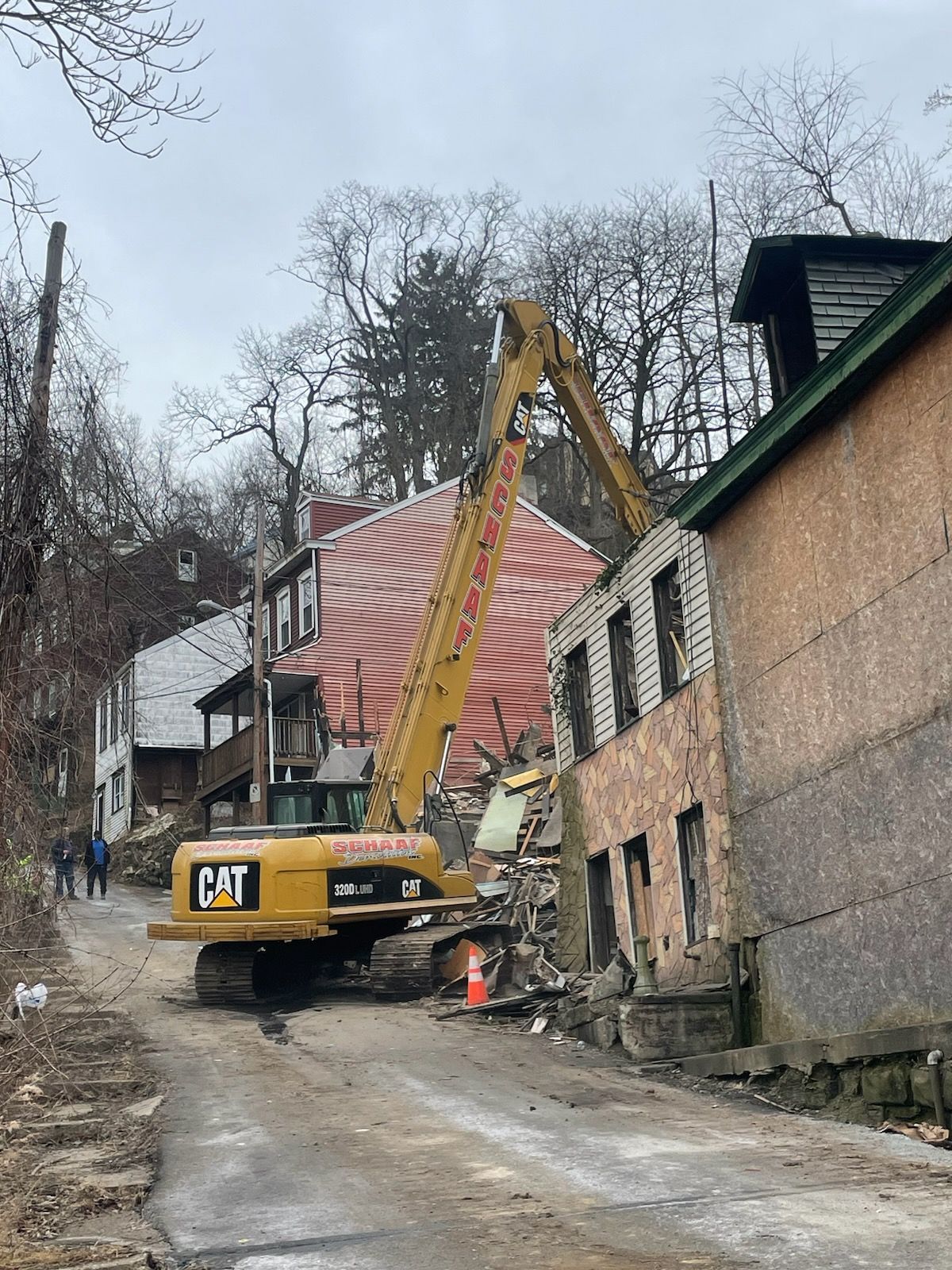 high reach excavator demoing a home