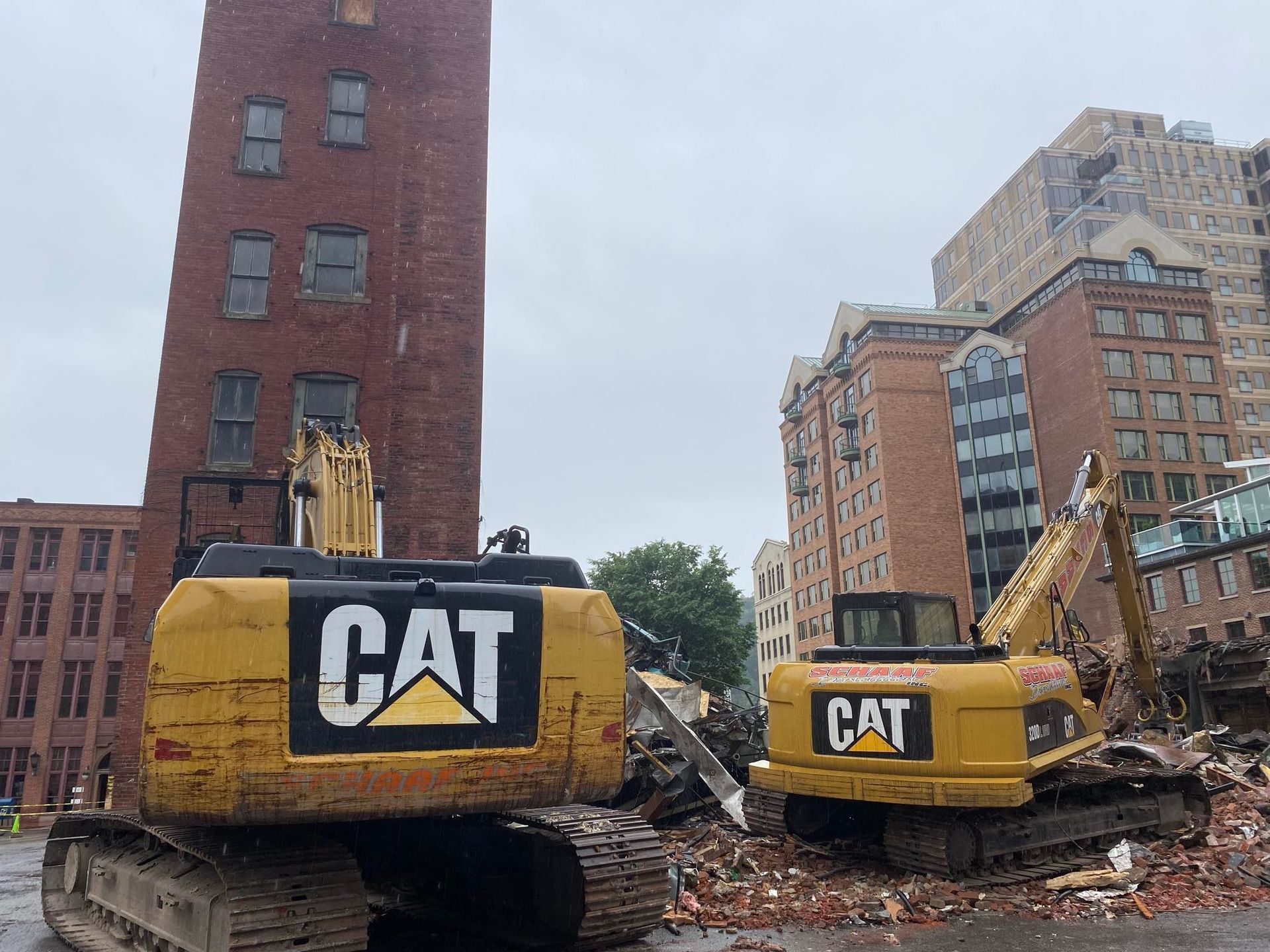Two large CAT excavators involved in demolition viewed from the rear.