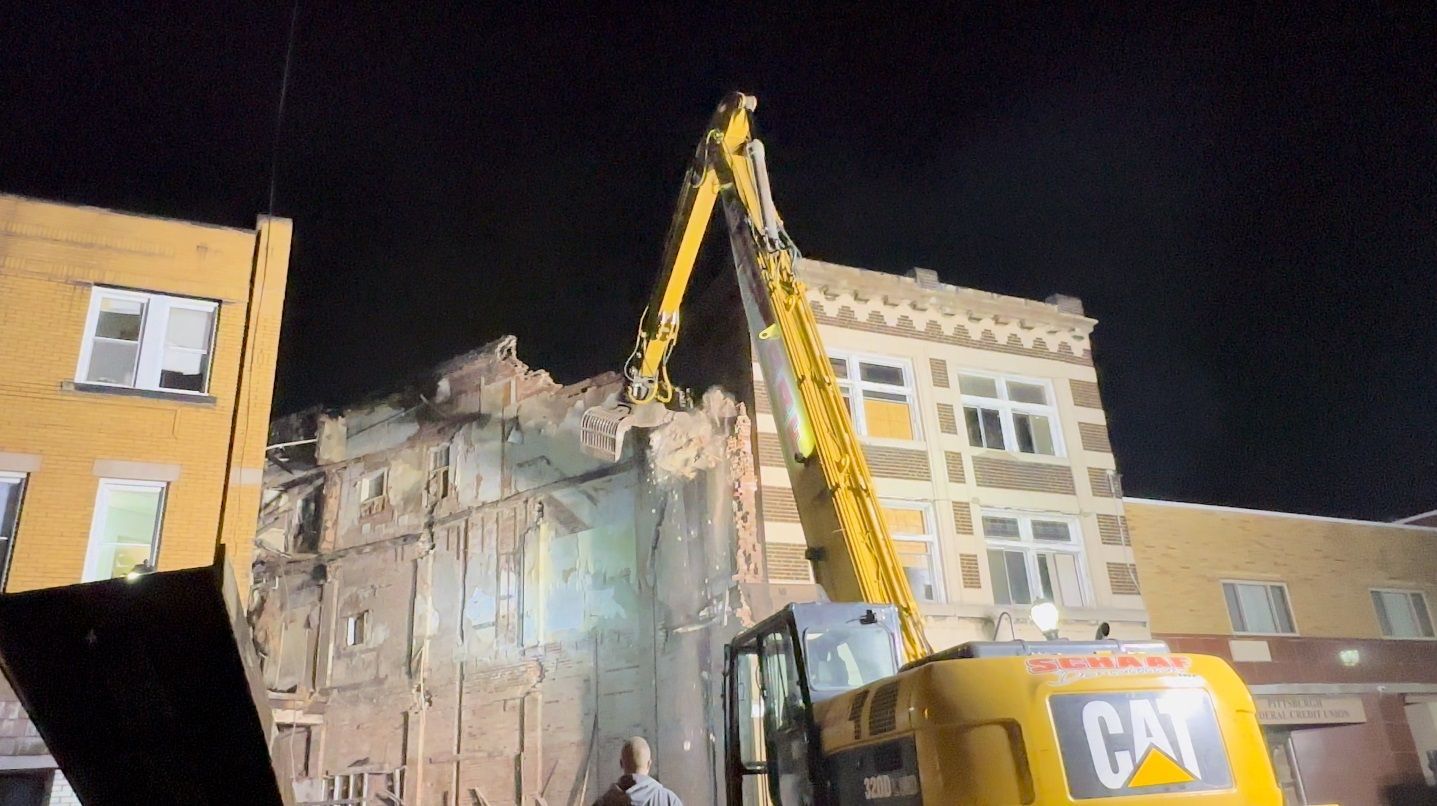 CAT machine pulling down walls in a commercial selective demolition job