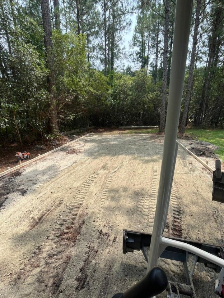 A golf cart is driving down a dirt road in the woods.