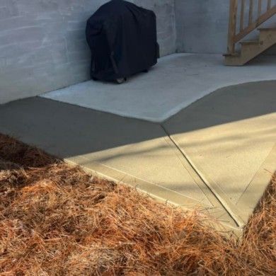 A black backpack is sitting on a sidewalk next to a staircase.
