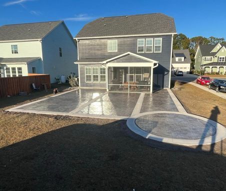 A large house with a concrete patio in front of it.