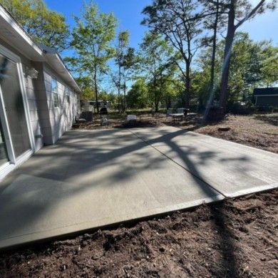 A concrete patio is being built in front of a house.