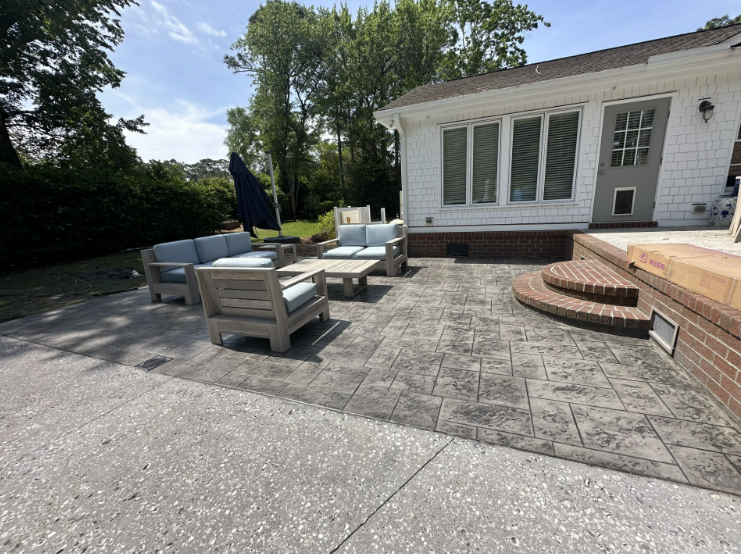 A large house with a concrete patio in front of it.