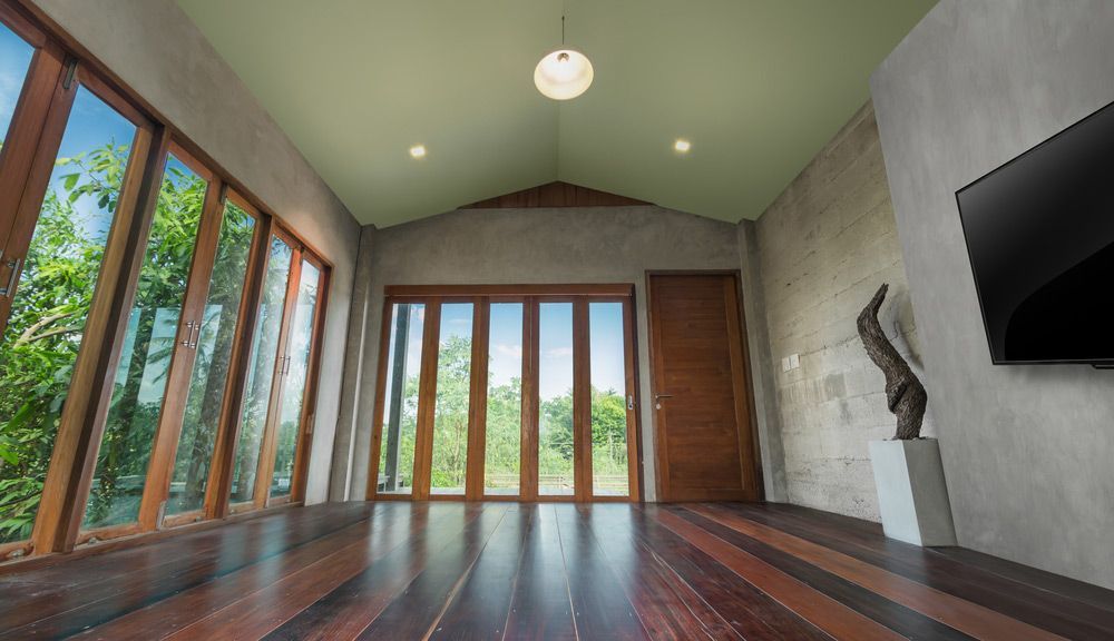 Folding Doors With Tall Windows Tv On Concrete Wall Old Wooden Floor In Empty Living Room Interior — Premium-Quality Internal Doors in Mackay, QLD