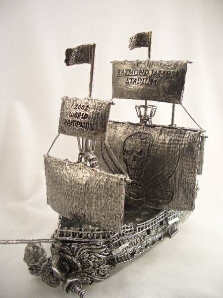 a silver model of a pirate ship with flags on the sails