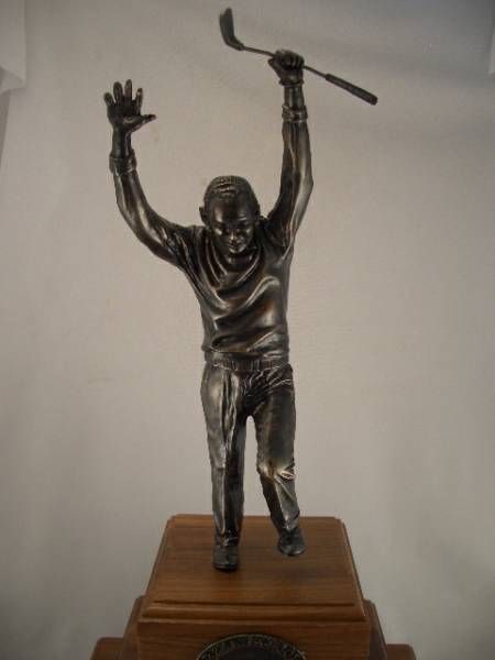 a statue of a man holding a golf club over his head