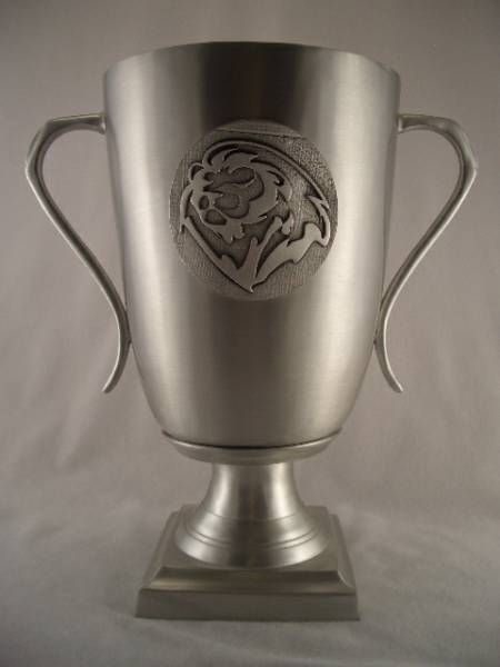 a silver trophy with a lion on it is sitting on a table .