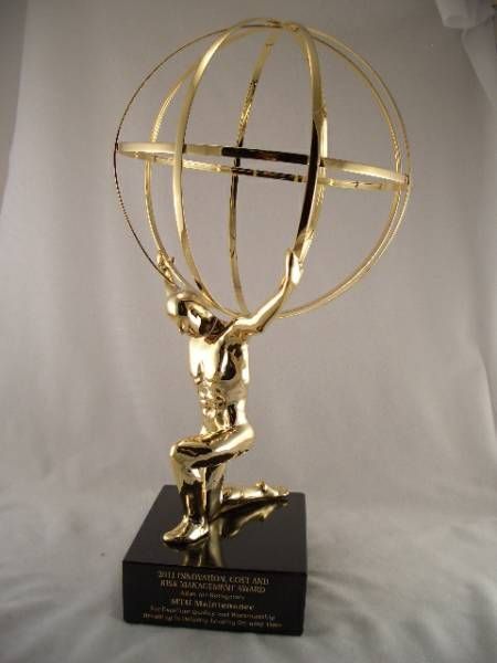 a gold statue of a man holding a globe