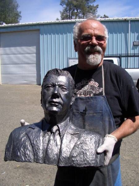 a man in an apron is holding a statue of a man